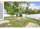 A backyard with a large tree, white fence, a shed, and a well-maintained lawn at 604 Mills St, Raleigh, NC 27608