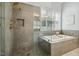 Bathroom showcasing glass enclosed shower, soaking tub, neutral tile, large window, and gold fixtures at 604 Mills St, Raleigh, NC 27608
