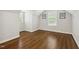 A bedroom with hardwood floors, neutral walls, and two windows that provide natural light at 604 Mills St, Raleigh, NC 27608