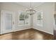 Dining room with hardwood floors, modern chandelier, and bright natural light from the surrounding windows at 604 Mills St, Raleigh, NC 27608