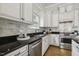 Updated kitchen featuring granite counters, white cabinets, subway tile backsplash, and stainless steel appliances at 604 Mills St, Raleigh, NC 27608