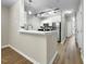 Modern kitchen with white cabinets, stainless steel appliances, and a breakfast bar at 65 Forest Oaks Dr, Durham, NC 27705