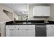 Well-lit kitchen featuring sleek black countertops and crisp white cabinets at 65 Forest Oaks Dr, Durham, NC 27705