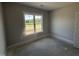 A bright, empty bedroom features a window with views of the outdoors at 69 Tee Dr, Selma, NC 27576