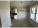 Dining room showing wainscoting details, a modern chandelier and a view into the kitchen, which has white cabinets at 69 Tee Dr, Selma, NC 27576