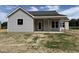 Newly built home with light gray vinyl siding and a covered front porch at 69 Tee Dr, Selma, NC 27576