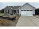 New construction home featuring gray siding, stone accents, and a two-car garage at 69 Tee Dr, Selma, NC 27576