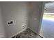 Laundry room featuring hookups and tiled floors, leading to an open garage and backyard at 69 Tee Dr, Selma, NC 27576