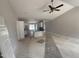 Spacious open-concept living area with a ceiling fan, connected to a kitchen with white cabinets and blue countertops at 69 Tee Dr, Selma, NC 27576