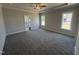 Carpeted main bedroom with tray ceiling, fan, and windows for natural light at 69 Tee Dr, Selma, NC 27576