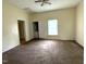 Living room with neutral walls, ceiling fan, window, carpeted floor, and two doorways at 702 Mill St, Wake Forest, NC 27587