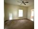 A bright living room with neutral walls, ceiling fan, window and carpeted floor at 702 Mill St, Wake Forest, NC 27587