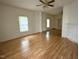 Bright living room with wood floors, ceiling fan, and natural light from windows at 702 Mill St, Wake Forest, NC 27587