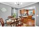 Open dining area showcases a stylish chandelier, rich hardwood floors, and flows into an adjacent updated kitchen at 708 W Pope St, Dunn, NC 28334
