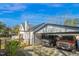 Exterior angle of a white house with carport and two cars parked underneath, framed by mature landscaping at 708 W Pope St, Dunn, NC 28334