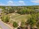 Scenic aerial view of a golf course and surrounding neighborhood with lush greenery at 725 Ancient Oaks Dr, Holly Springs, NC 27540