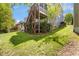 The home's backyard features a wooden deck, lush grass, and manicured bushes at 725 Ancient Oaks Dr, Holly Springs, NC 27540