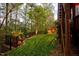 Beautiful backyard with lush lawn, mature trees and decorative black metal fence at 725 Ancient Oaks Dr, Holly Springs, NC 27540