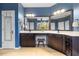 Bathroom with dual vanity sinks, dark cabinets, tile flooring, and a walk-in shower offering a luxurious feel at 725 Ancient Oaks Dr, Holly Springs, NC 27540