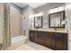 Bathroom features granite countertops, dark wood cabinets, and combined tub and shower at 725 Ancient Oaks Dr, Holly Springs, NC 27540