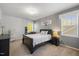 Cozy bedroom with neutral walls, a bed with patterned bedding, and a chandelier at 725 Ancient Oaks Dr, Holly Springs, NC 27540