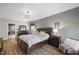 Large bedroom with hardwood floors features a queen sized bed, a dresser, and a sitting area with a faux fur throw at 725 Ancient Oaks Dr, Holly Springs, NC 27540