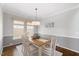 Elegant dining room with wainscoting, modern lighting, and a wooden table set for six at 725 Ancient Oaks Dr, Holly Springs, NC 27540
