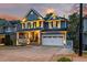 Charming two-story home with a covered front porch and attached two-car garage at 725 Ancient Oaks Dr, Holly Springs, NC 27540