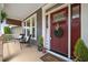 Inviting front porch with seating area, decorative door wreath, and stylish decor at 725 Ancient Oaks Dr, Holly Springs, NC 27540
