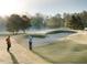 Scenic view of golfers on a course with sand traps and tree-lined fairways at 725 Ancient Oaks Dr, Holly Springs, NC 27540