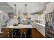 Modern kitchen featuring an island with bar seating, stainless appliances, and stylish pendant lighting at 725 Ancient Oaks Dr, Holly Springs, NC 27540