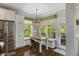Bright kitchen nook with stainless steel appliances, built-in bench seating, and outdoor access at 725 Ancient Oaks Dr, Holly Springs, NC 27540