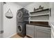 A practical laundry room is equipped with stacked washer and dryer units and storage cabinets at 725 Ancient Oaks Dr, Holly Springs, NC 27540