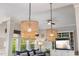 The open concept living room features natural lighting from the large window and custom light fixtures at 725 Ancient Oaks Dr, Holly Springs, NC 27540