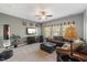 Comfortable living room with ceiling fan, leather couches, and neutral carpet at 725 Ancient Oaks Dr, Holly Springs, NC 27540