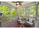 Relaxing screened porch with comfortable seating, wood floors, and a view of the trees at 725 Ancient Oaks Dr, Holly Springs, NC 27540