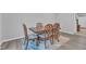 A wooden dining table and chairs sit on a patterned rug in the dining area at 8601 Red Canyon Way, Raleigh, NC 27616