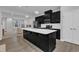 Modern kitchen features dark cabinetry, stainless steel appliances, a center island, and opens to a living area at 8601 Red Canyon Way, Raleigh, NC 27616