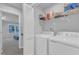 Functional laundry room with white washer and dryer, storage shelves, and a folding door at 8601 Red Canyon Way, Raleigh, NC 27616