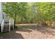 Backyard view showing fenced in yard with flowers in bloom and steps to deck at 901 Clifford Dr, Durham, NC 27704