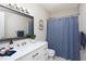 Stylish bathroom featuring a white vanity with quartz countertop, modern fixtures, and a blue shower curtain at 901 Clifford Dr, Durham, NC 27704