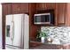 Bright kitchen boasts stainless steel refrigerator and built in microwave over granite counters at 901 Clifford Dr, Durham, NC 27704