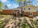 Backyard featuring a wooden deck with stairs leading to a patio, brick exterior, and lush lawn at 901 Forge Rd, Durham, NC 27713