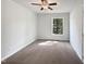 Cozy bedroom featuring neutral carpet, bright window, and a ceiling fan at 901 Forge Rd, Durham, NC 27713