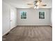 Bright bedroom featuring a ceiling fan, two windows, and carpeted floors at 901 Forge Rd, Durham, NC 27713