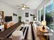 Bright living room with large windows, modern furniture and a ceiling fan at 901 Forge Rd, Durham, NC 27713