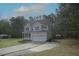 Traditional two-story home with a two-car garage, light siding, blue shutters and mature trees at 910 Cedar Creek Dr, Wendell, NC 27591