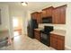 Galley kitchen with black appliances, wood cabinets and tiled floors at 910 Cedar Creek Dr, Wendell, NC 27591