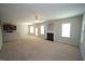 Open-concept living room featuring a fireplace, neutral carpet, and generous natural light from windows and exterior doors at 910 Cedar Creek Dr, Wendell, NC 27591