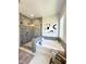 A modern bathroom showcasing a tiled shower, a soaking tub, neutral paint and a large window at 964 Double Helix Rd, Apex, NC 27523
